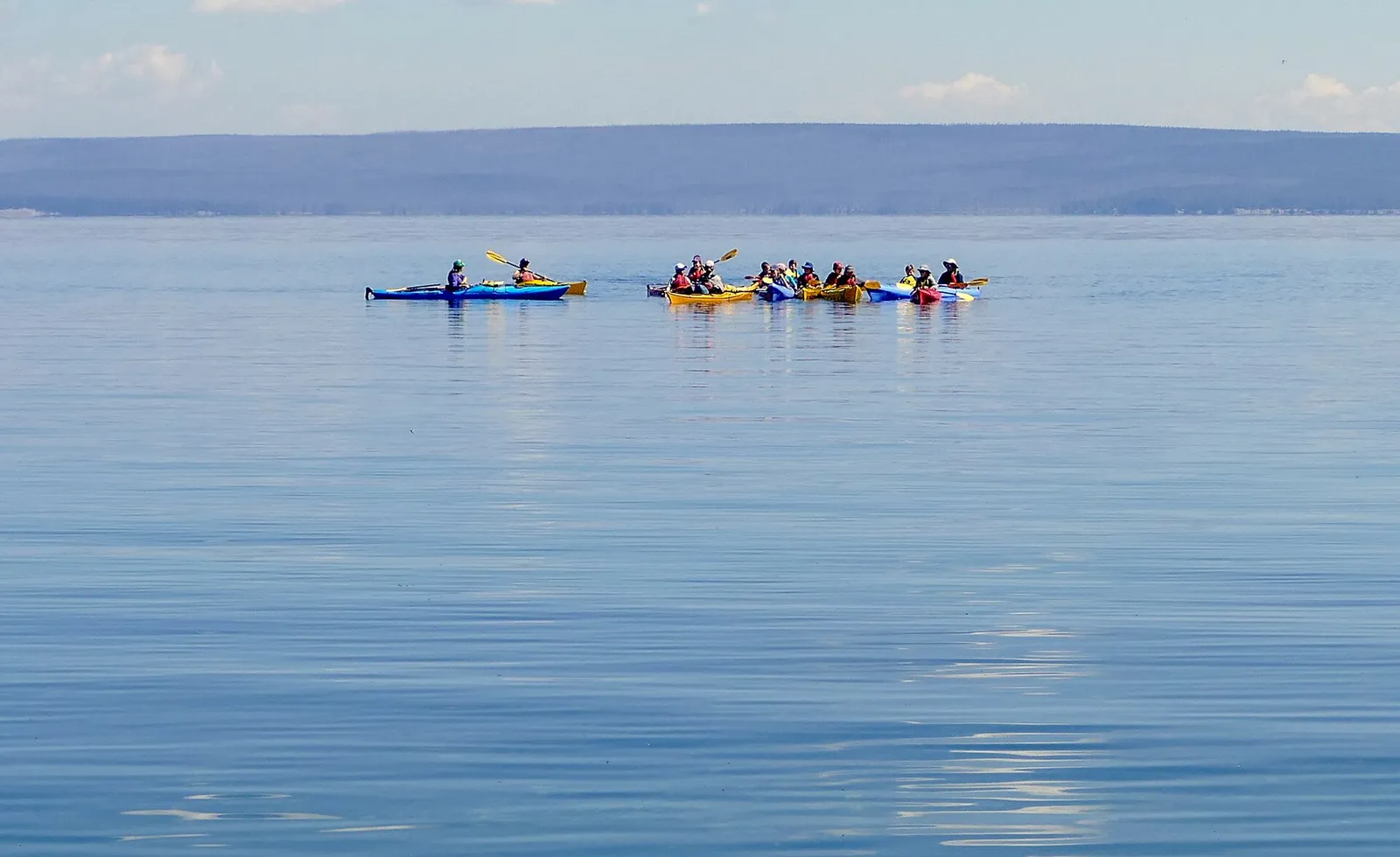 Kayakistes en randonnée sur un grand lac de montagne